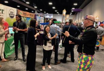Soo Choi of Rainier Fruit Co., Selah, Wash., attempts to balance plates on sticks as part of the Mardi Gras-themed festivities at Southeast Produce Council’s Southern Exposure trade show Feb. 27-29 in Tampa, Fla.