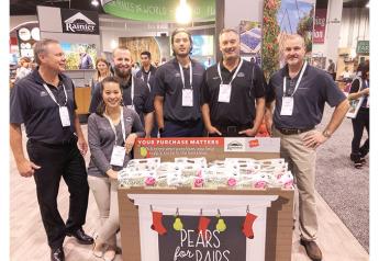 Representatives of Rainier Fruit Co. show off a retail display for the company’s Pears for Pairs promo during Fresh Summit 2019