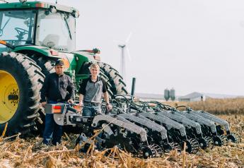 Raymond (left) and Raymond Claire (right) of Zimmerman Manufacturing stand with their strip-till machine.