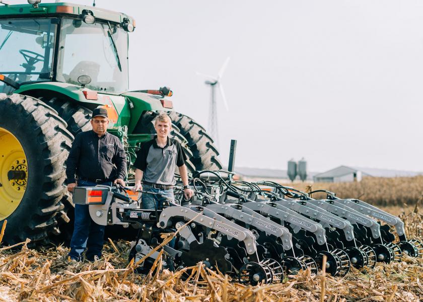 Raymond (left) and Raymond Claire (right) of Zimmerman Manufacturing stand with their strip-till machine.